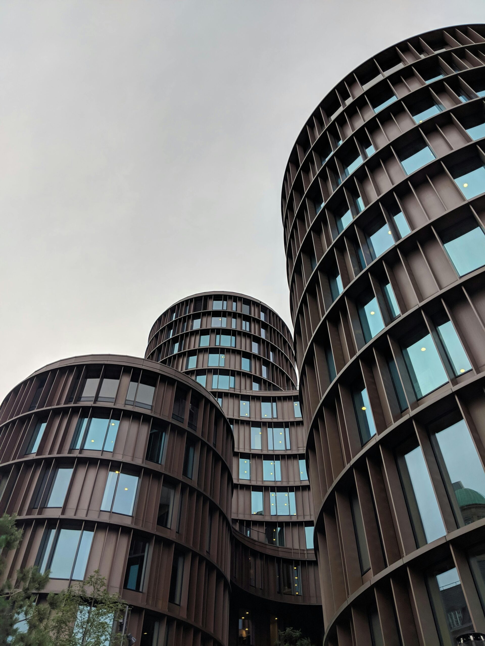 "A low-angle view of the circular Axel Towers in Copenhagen, symbolizing the structured 'Systems' of policy and finance.